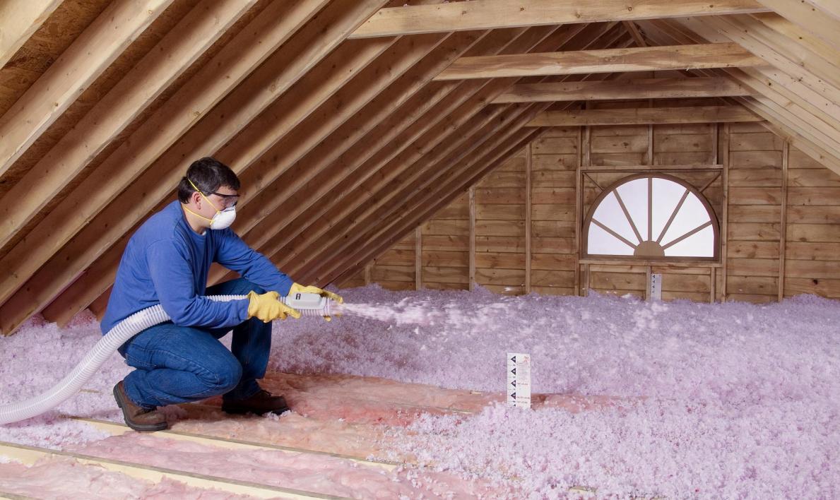 Image of attic joists with insulation being applied to it